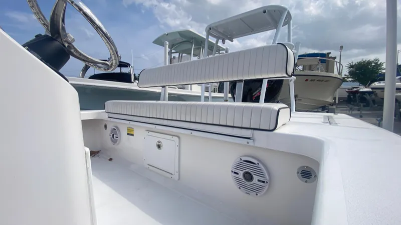 Slide: The Image of 2025 Piranha F2000 boat interior with white seating and steering wheel, under a cloudy sky. - 6