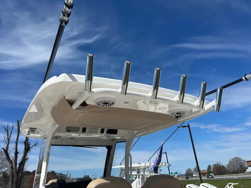 Slide: The Image of 2024 Everglades 315 Center Console boat with rod holders and speakers under a clear blue sky. - 18