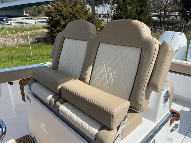 Slide: The Image of 2024 Everglades 315 Center Console boat with beige and white cushioned seats. - 19