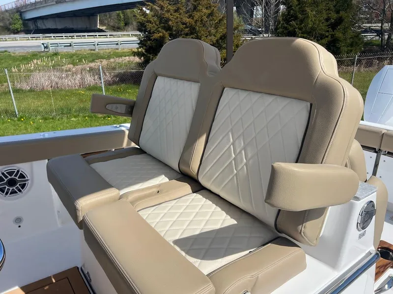 Slide: The Image of 2024 Everglades 315 Center Console boat with beige and white cushioned seating. - 20
