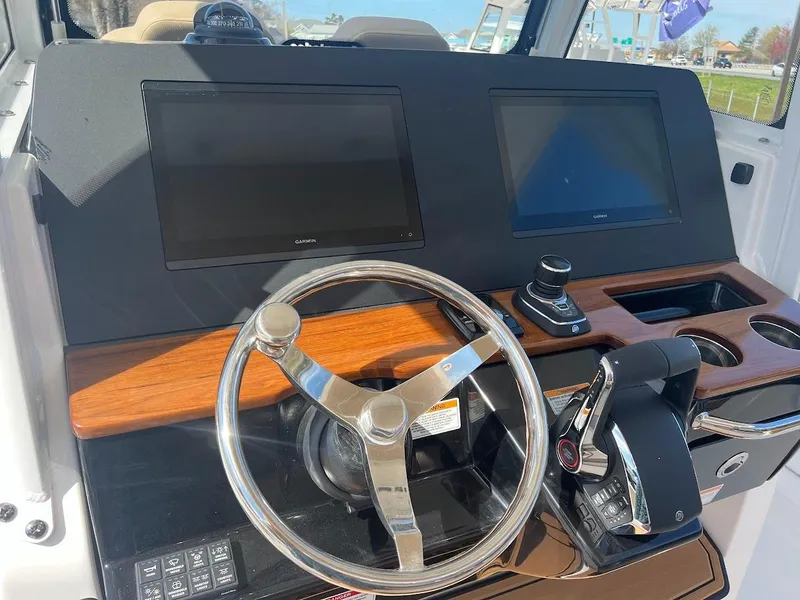 Slide: The Image of 2024 Everglades 315 Center Console helm with dual screens and steering wheel. - 21