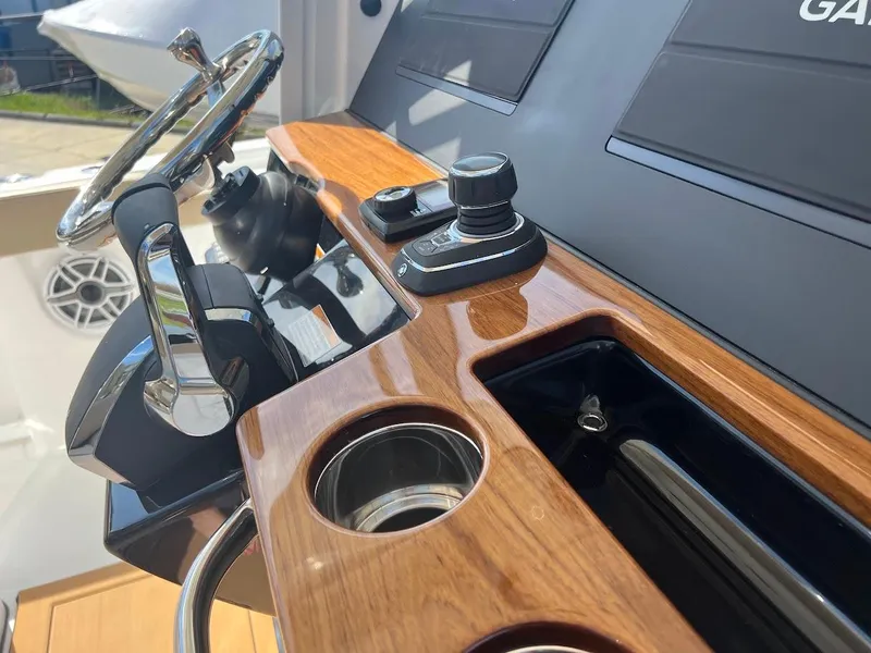Slide: The Image of 2024 Everglades 315 Center Console helm with wood trim and modern controls. - 24