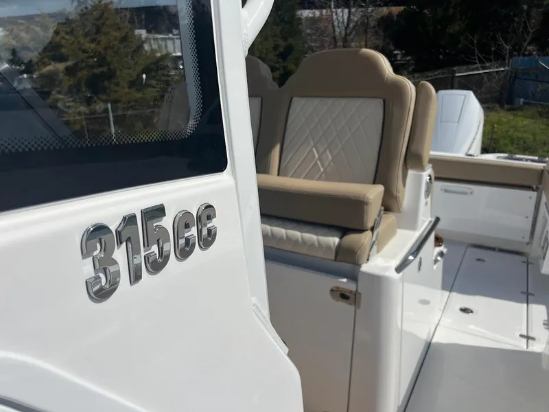 Slide: The Image of 2024 Everglades 315 Center Console boat with beige seating and 315cc logo. - 32