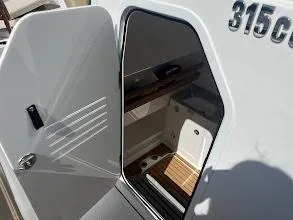Slide: The Image of 2024 Everglades 315 Center Console cabin interior with open door. - 33