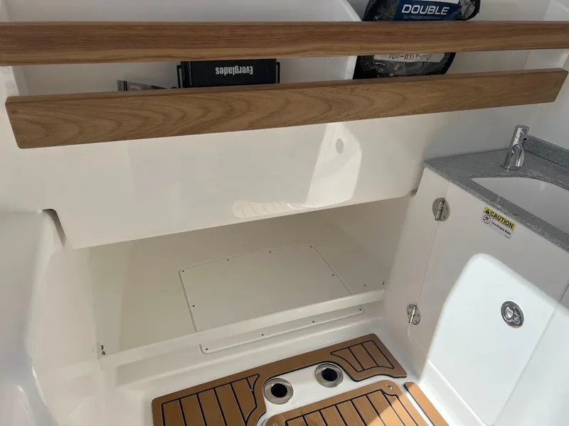 Slide: The Image of Interior of 2024 Everglades 315 Center Console boat with wooden accents and storage compartments. - 35