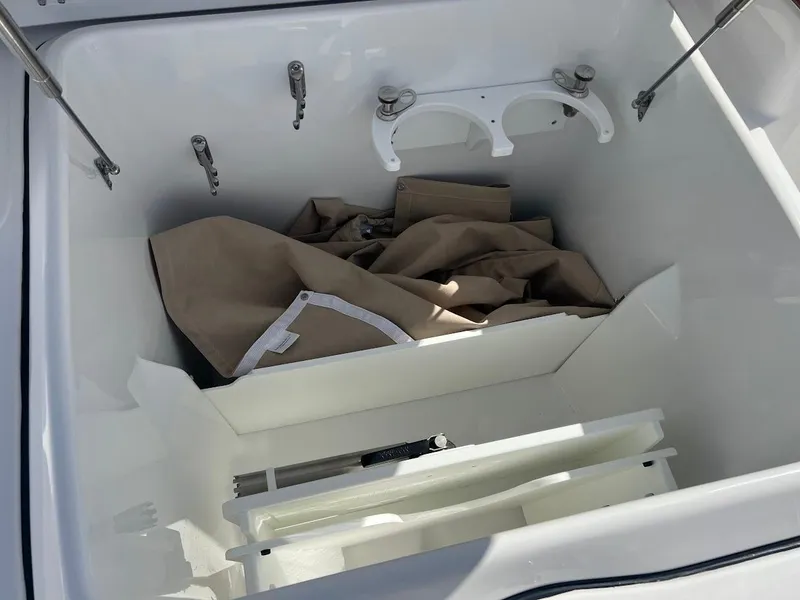 Slide: The Image of Storage compartment of 2024 Everglades 315 Center Console boat with beige cover inside. - 47