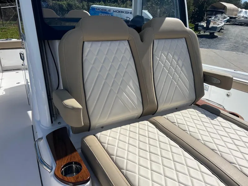 Slide: The Image of 2024 Everglades 315 Center Console boat with beige diamond-stitched seats. - 48