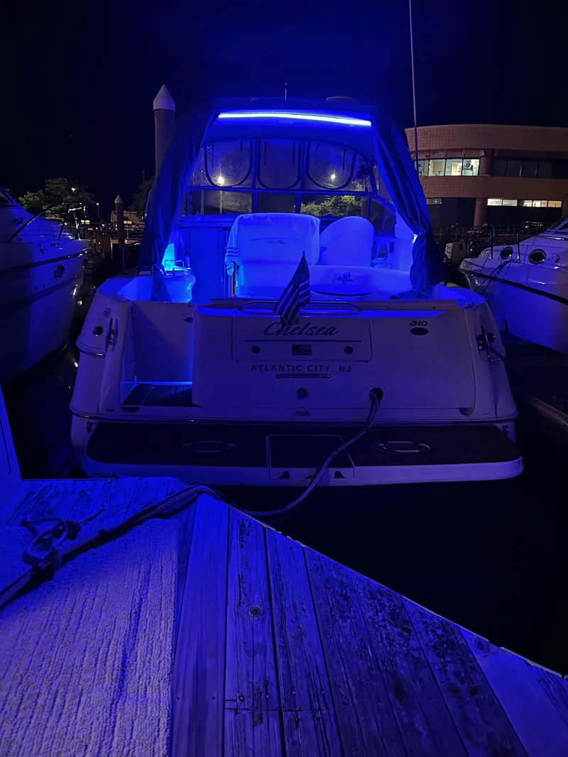 Slide: The Image of Sea Ray 310 Sundancer 2002 yacht illuminated with blue lights at night. - 10