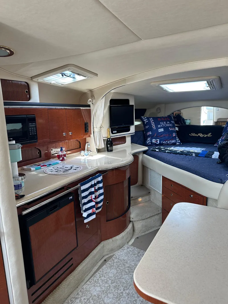 Slide: The Image of Interior of 2002 Sea Ray 310 Sundancer with kitchenette and cozy sleeping area. - 15
