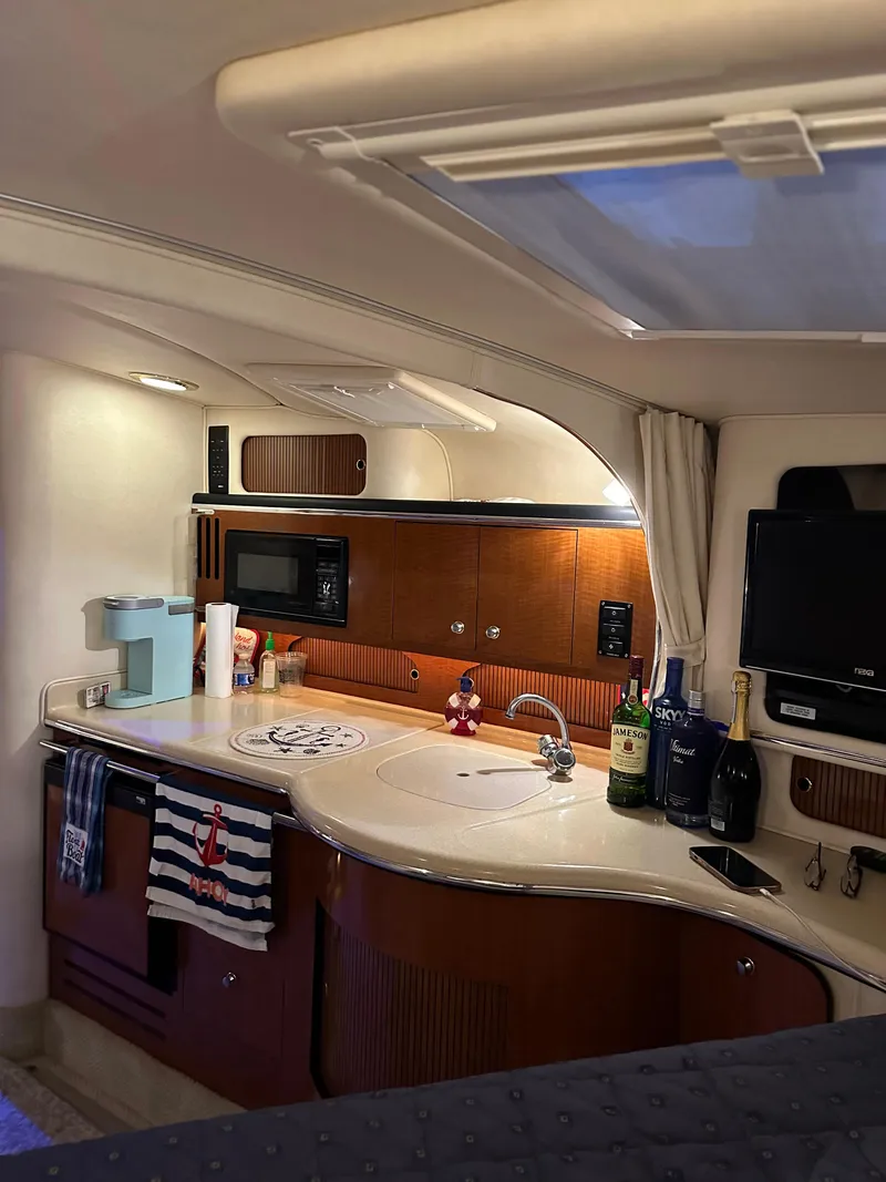 Slide: The Image of 2002 Sea Ray 310 Sundancer cabin kitchen with modern amenities. - 19