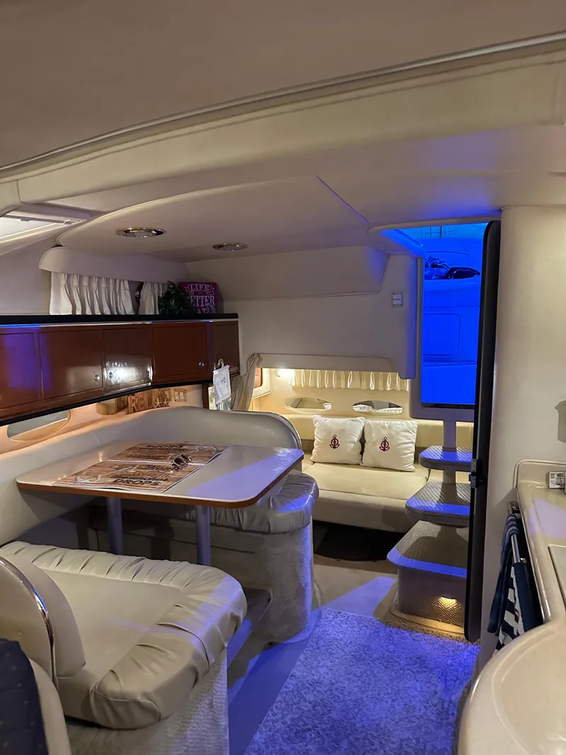 Slide: The Image of Interior of 2002 Sea Ray 310 Sundancer yacht with dining area and cozy seating. - 20