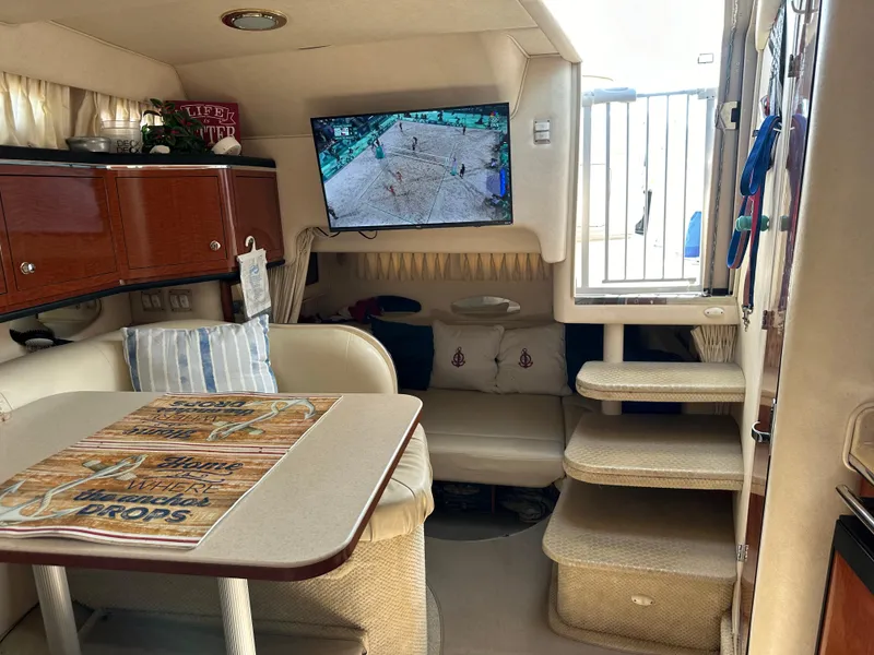 Slide: The Image of Interior of 2002 Sea Ray 310 Sundancer with TV, dining area, and stairs. - 24