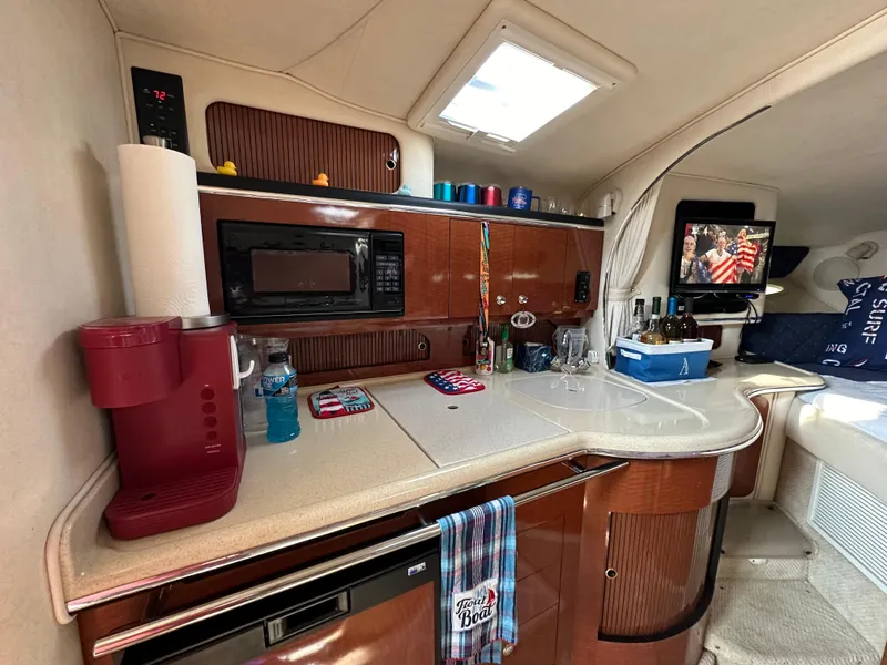 Slide: The Image of Interior of 2002 Sea Ray 310 Sundancer with kitchenette and modern amenities. - 26