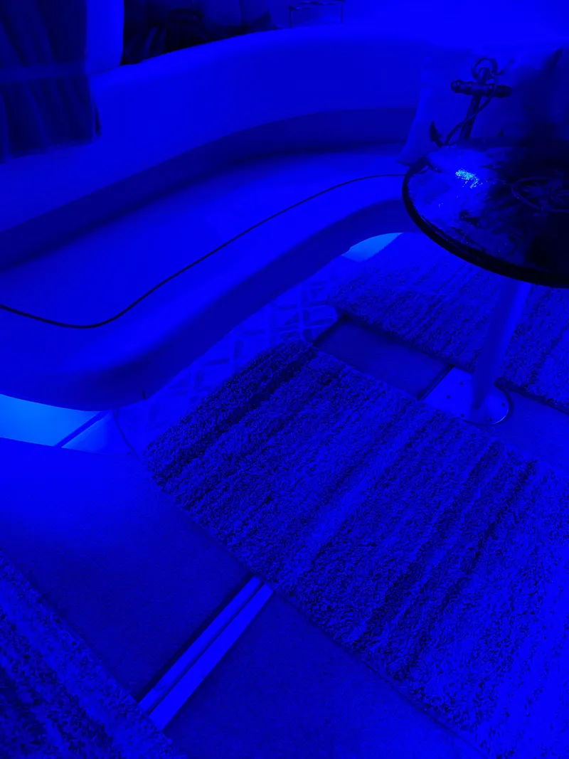 Slide: The Image of Interior of 2002 Sea Ray 310 Sundancer with blue lighting and cozy seating area. - 35