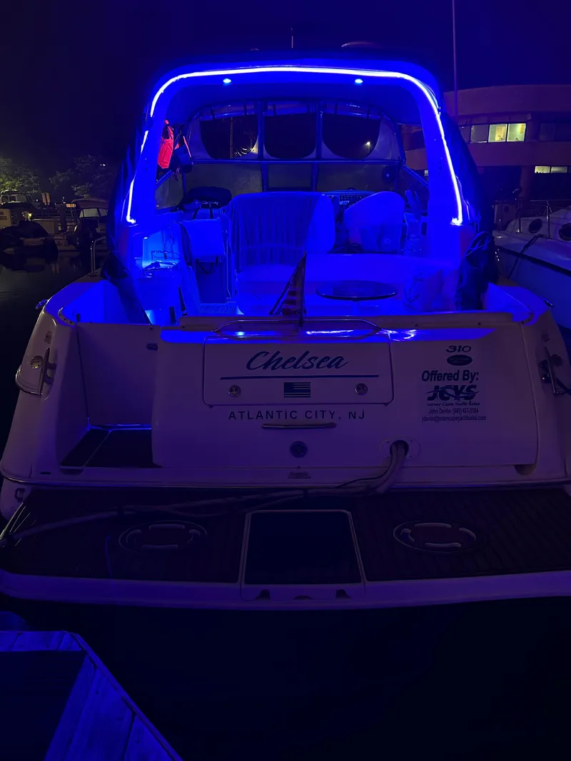 Slide: The Image of 2002 Sea Ray 310 Sundancer boat with blue LED lights, docked at night. - 38