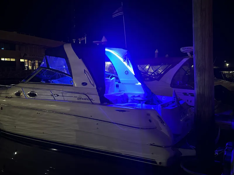 Slide: The Image of 2002 Sea Ray 310 Sundancer yacht illuminated with blue lights at night. - 41