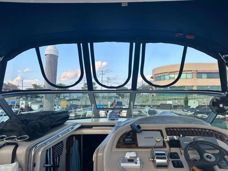 Slide: The Image of Interior view of 2002 Sea Ray 310 Sundancer boat cockpit with marina background. - 45