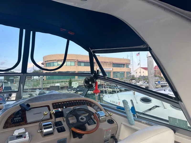 Slide: The Image of Interior view of 2002 Sea Ray 310 Sundancer boat cockpit with marina backdrop. - 46
