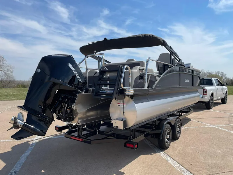 Slide: The Image of 2024 Barletta Cabrio 22UC pontoon boat on a trailer, with a Mercury outboard motor. - 10