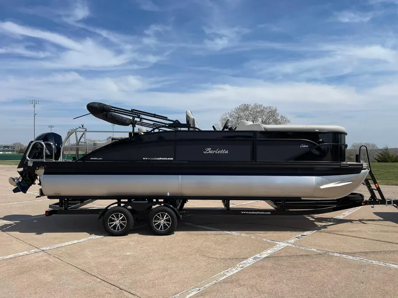 Slide: The Image of 2024 Barletta Cabrio 22UC pontoon boat on a trailer under a clear sky. - 12