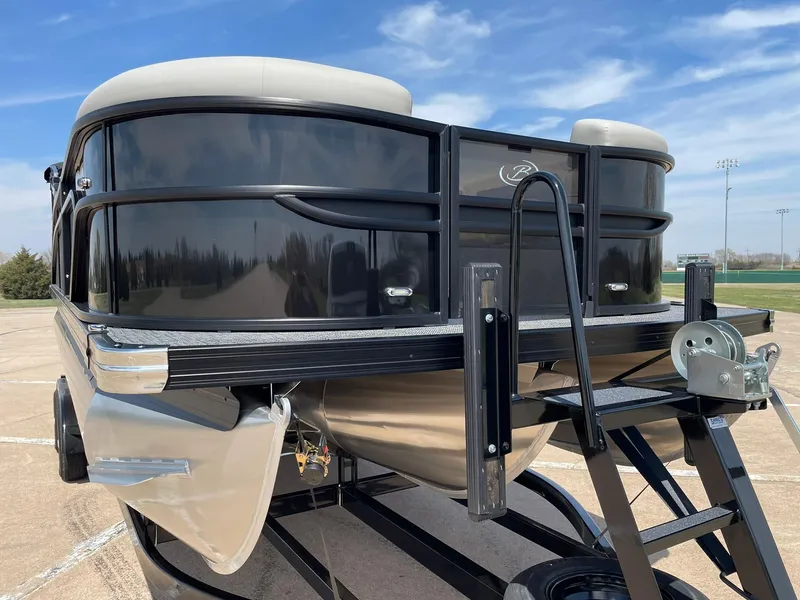 Slide: The Image of 2024 Barletta Cabrio 22UC pontoon boat on trailer, front view under blue sky. - 15