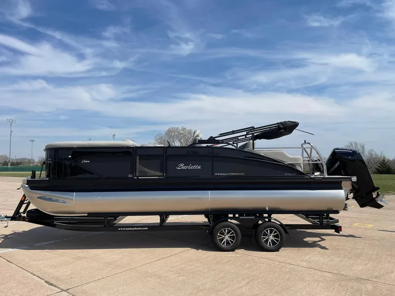 Slide: The Image of 2024 Barletta Cabrio 22UC pontoon boat on a trailer under a clear sky. - 2