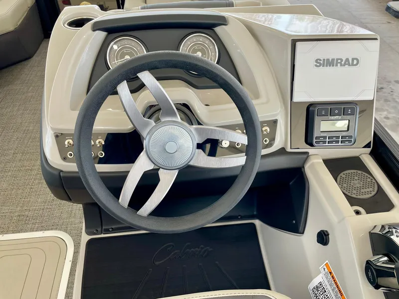 Slide: The Image of 2024 Barletta Cabrio 22UC boat dashboard with steering wheel and Simrad display. - 26