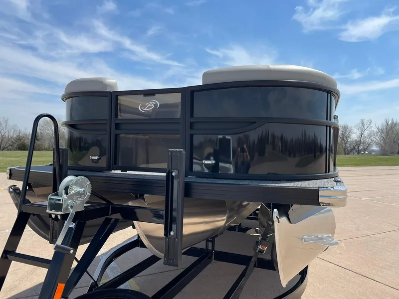 Slide: The Image of 2024 Barletta Cabrio 22UC pontoon boat on a trailer under a clear blue sky. - 5