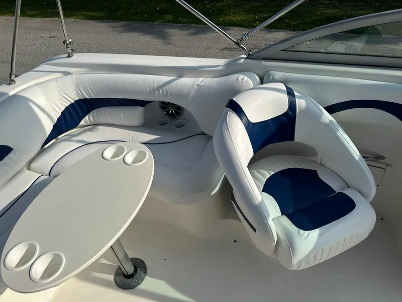 Slide: The Image of 2008 NauticStar 23DC boat interior with white and blue seating and a table. - 11