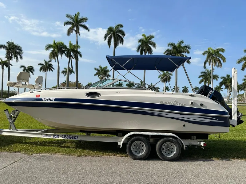 Slide: The Image of 2008 NauticStar 23DC boat on a trailer with palm trees in the background. - 5