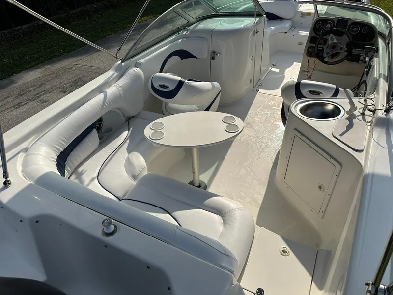 Slide: The Image of 2008 NauticStar 23DC boat interior with white seating, table, and steering console. - 9