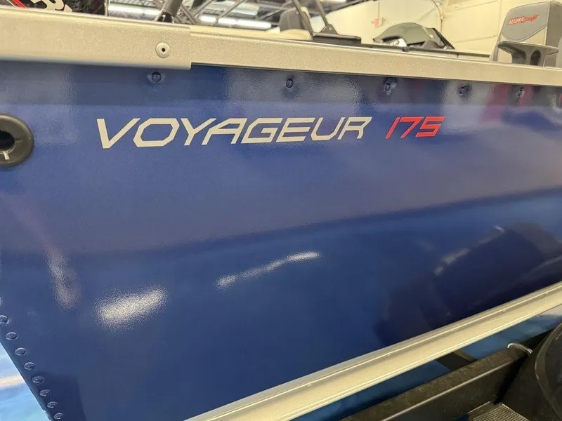Slide: The Image of 2024 Alumacraft Voyageur 175 Tiller boat side view in blue. - 2