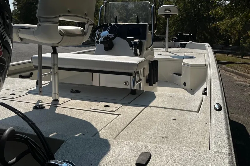 Slide: The Image of 2024 Ranger RB210 boat interior with seating and steering console, parked outdoors. - 5