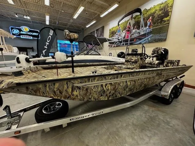 Slide: The Image of 2024 Ranger RB210 camo fishing boat on trailer in showroom. - 1