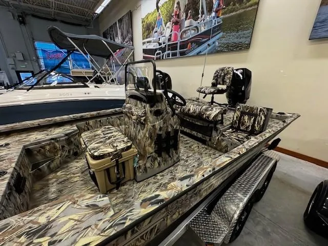 Slide: The Image of 2024 Ranger RB210 boat with camouflage design in showroom. - 2