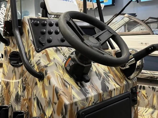 Slide: The Image of 2024 Ranger RB210 boat dashboard with camo design and steering wheel. - 4