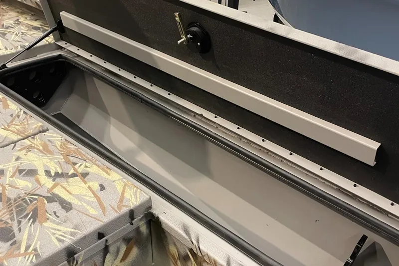 Slide: The Image of 2024 Ranger RB210 boat storage compartment with camo interior. - 6