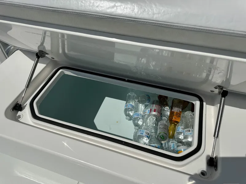 Slide: The Image of Built-in cooler on 2022 Contender 39 ST boat with water bottles and beverages. - 28
