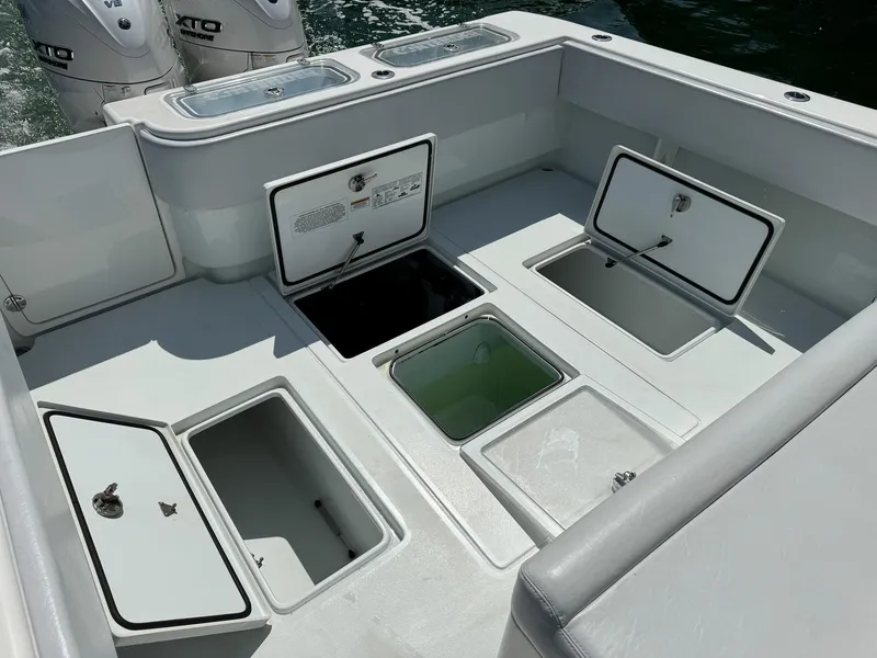 Slide: The Image of 2022 Contender 39 ST boat with open storage compartments and twin outboard engines. - 29