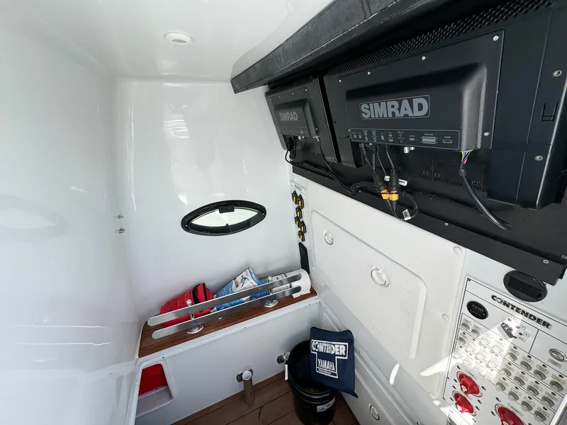 Slide: The Image of 2022 Contender 39 ST boat interior with Simrad electronics and storage area. - 39
