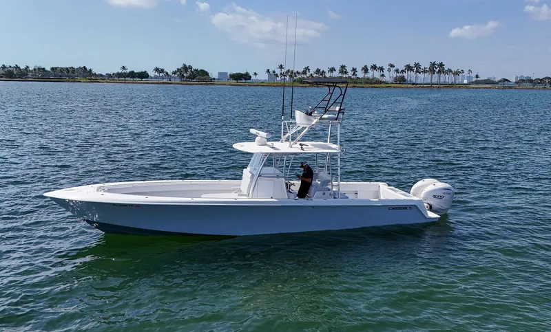Slide: The Image of 2022 Contender 39 ST boat on calm waters with a scenic shoreline. - 43