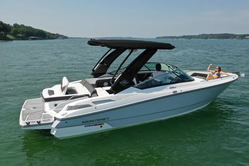 The Image of 2023 Monterey 298SS boat on a lake with a person relaxing onboard. - 0