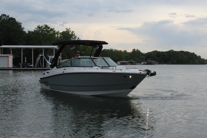 Slide: The Image of 2023 Monterey 298SS boat cruising on a lake near a dock. - 29