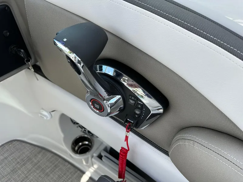 Slide: The Image of 2024 Crownline Eclipse E260 XS boat interior with steering wheel and Garmin navigation system. - 13