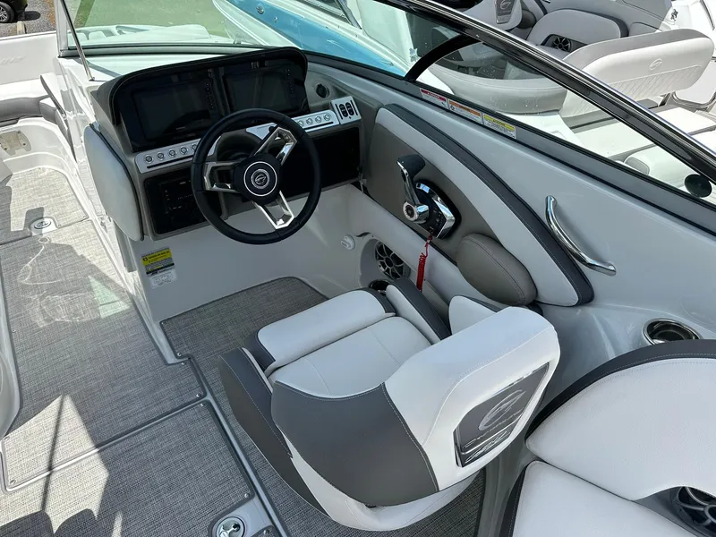 Slide: The Image of 2024 Crownline Eclipse E260 XS boat dashboard with dual Garmin displays and steering wheel. - 8