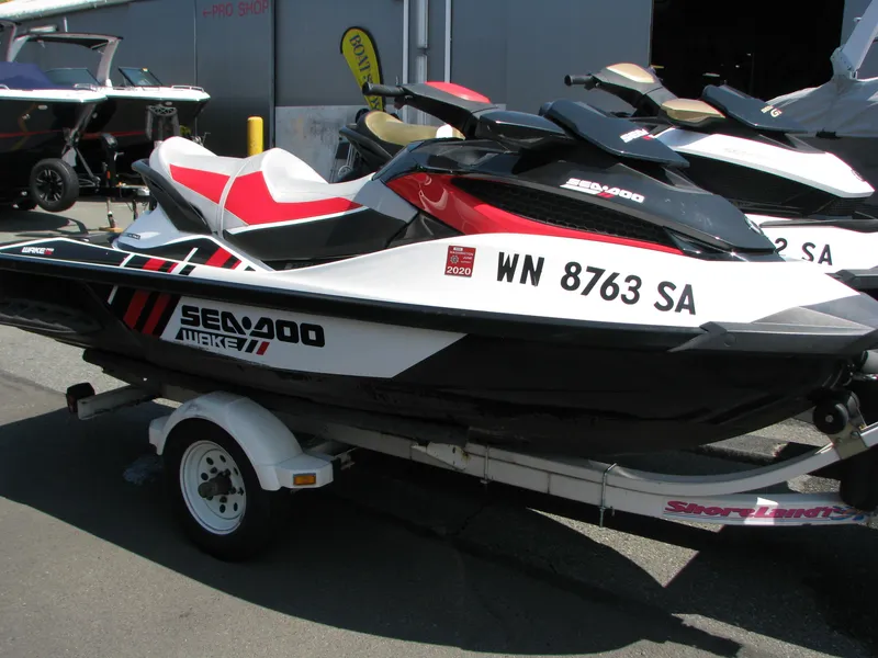 The Image of 2013 Sea-Doo WAKE PRO jet ski on a trailer, parked outdoors. - 0