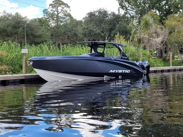 The Image of 2024 Mystic Powerboats 42 CC on calm water near a dock. - 0
