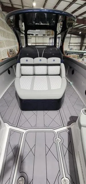 Slide: The Image of 2024 Mystic Powerboats 42 CC interior with cushioned seating and modern design. - 6