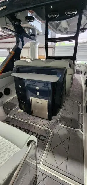 Slide: The Image of 2024 Mystic Powerboats 42 CC interior with modern seating and sleek design. - 7