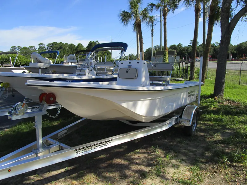 Slide: The Image of 2024 Carolina Skiff E Series E16 JVX CC boat on a trailer, parked outdoors. - 2